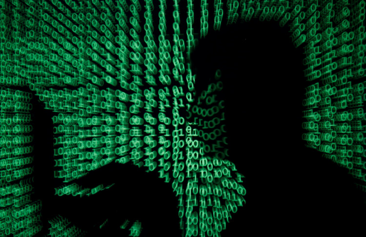 A man holds a laptop computer as cyber code is projected on him in this illustration picture