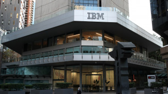 A man wearing a protective mask walks past an office building with IBM logo amidst the easing of the coronavirus disease (COVID-19) restrictions in Sydney
