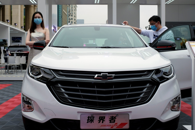 Model stands next to a Chevrolet vehicle at a sales event in Shanghai