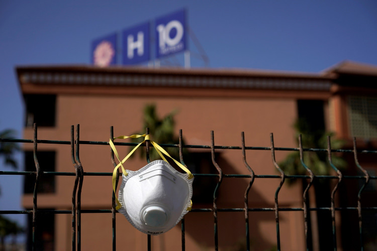 An abandoned mask is seen on a fence in front of H10 Costa Adeje Palace hotel, which is under lockdown over the coronavirus outbreak in Adeje