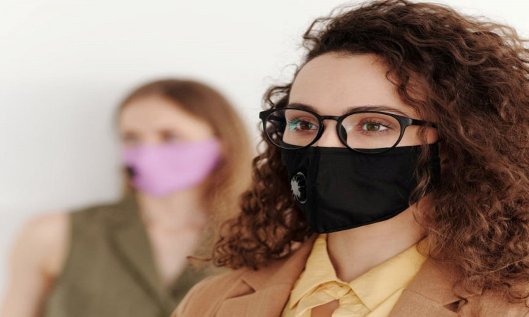 Woman wearing eyeglasses with face mask.