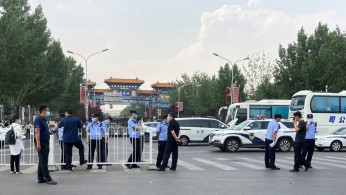 Police officers wearing face masks are seen outside an entrance of the Xinfadi wholesale market