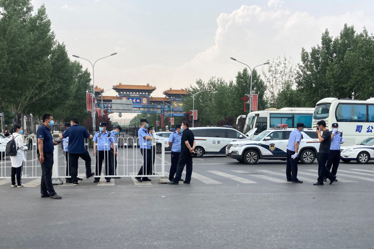 Police officers wearing face masks are seen outside an entrance of the Xinfadi wholesale market