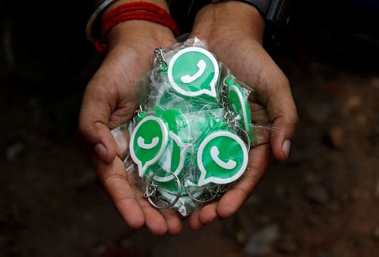 A WhatsApp-Reliance Jio representative displays keychains with the logo of WhatsApp for distribution during a drive by the two companies to educate users, on the outskirts of Kolkata