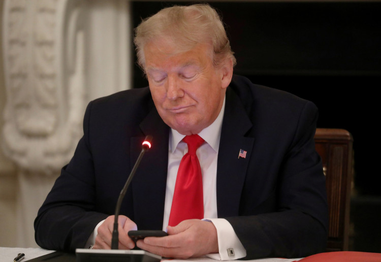 U.S. President Trump uses phone during roundtable discussion on the reopening of U.S. economy at the White House in Washington