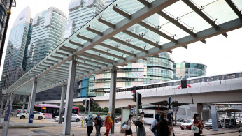 Office workers wearing protective masks cross a street near central business district, amid the coronavirus disease (COVID-19) outbreak in Kuala Lumpur