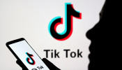 Person holds a smartphone with Tik Tok logo displayed in this picture illustration