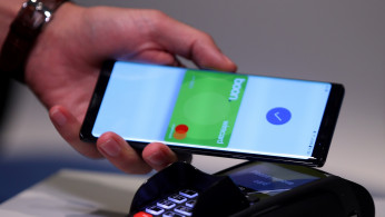 FILE PHOTO: An employee of Wirecard AG, presents the contactless payment system 