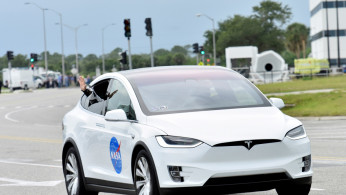 FILE PHOTO: NASA astronaut Douglas Hurley waves from his Tesla as they pass the VAB heading to Pad39A for the launch of the SpaceX Crew Dragon