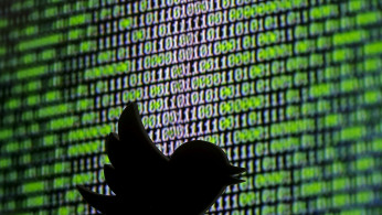 FILE PHOTO: 3D printed Twitter logo is seen in front of a displayed cyber code