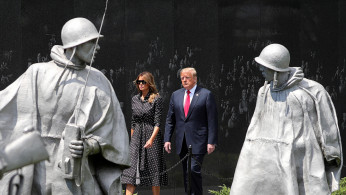 U.S. President Donald Trump and first lady Melania Trump walk past statues as they arrive for a wreath laying ceremony at the Korean War Veterans Memorial in Washington, U.S., June 25, 2020. REUTERS/Tom Brenner