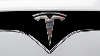 FILE PHOTO: The Tesla logo is seen on a car at Tesla's showroom in Manhattan's Meatpacking District in New York