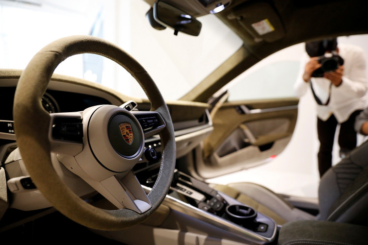 The logo of Porsche is pictured on the steering wheel of a Porsche 911 sports car 