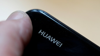 FILE PHOTO: A worker refurbishes a Huawei cell phone at a workshop of the Oxflo company