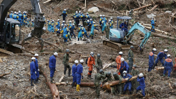 Rescue workers search for missing people at a landslide site