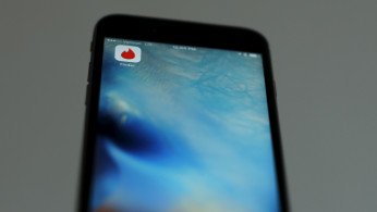 Photo illustration of dating app Tinder shown on an Apple iPhone
