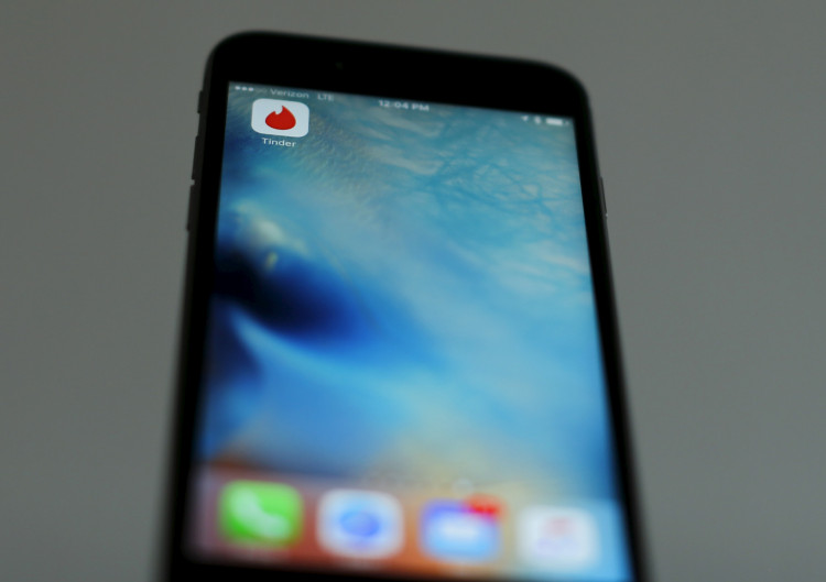 Photo illustration of dating app Tinder shown on an Apple iPhone