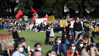 People attend a demonstration in solidarity with the Black Lives Matter (BLM) rallies in the United States