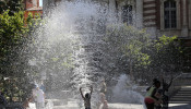 Children cool off during hot summer weather in a public fountain on the Charles de Gaulle square in Toulouse, France, July 8, 2020. 