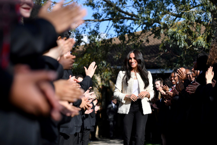 FILE PHOTO: Britain's Meghan, Duchess of Sussex, smiles as she is welcomed by students to visit the Robert Clack School in Essex