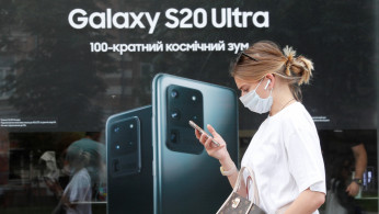 A woman walks past a Samsung brand store in central Kyiv