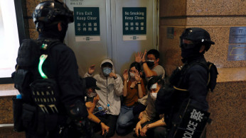 People detained by riot police during a march against national security law