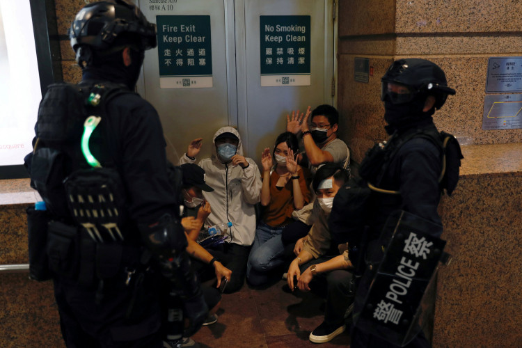 People detained by riot police during a march against national security law