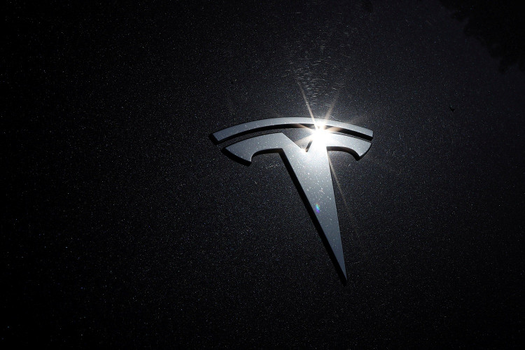 FILE PHOTO: The Tesla logo is seen on a car in Los Angeles, California, U.S., July 9, 2020. 
