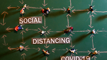 Small toy figures are placed on a chalkboard near 