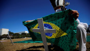 An activist puts a Brazilian flag painted with crosses on a cross