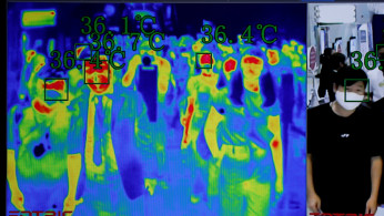 People are seen through the screen of a thermal scanner 
