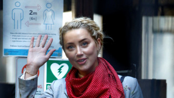 Actor Amber Heard waves as she arrives at the High Court