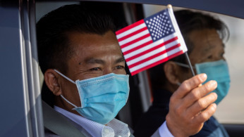 A man waves a U.S. flag after being sworn-in as a U.S. Citizen