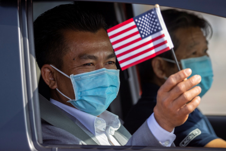 A man waves a U.S. flag after being sworn-in as a U.S. Citizen