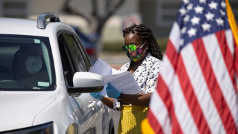 A U.S. immigration officer administer helps organize arriving vehicles 