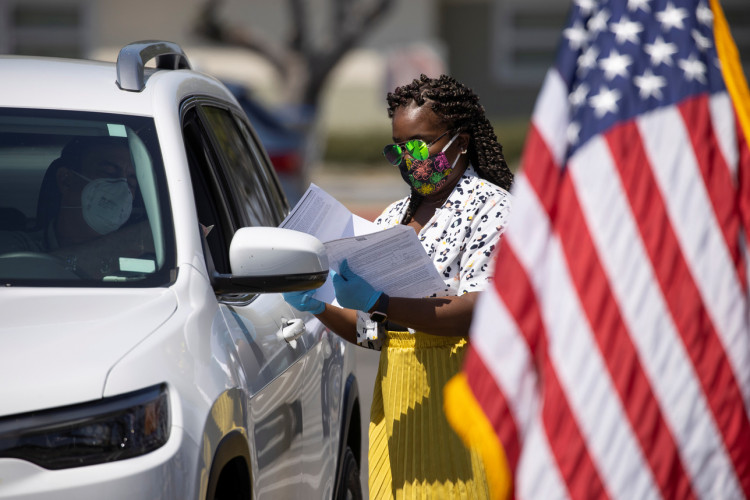 A U.S. immigration officer administer helps organize arriving vehicles 