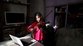 Marcela, 12, member of the Buenos Aires children's and youth orchestra program, practices her violin during a video call at home during the coronavirus pandemic