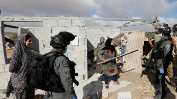 A Palestinian woman argues with Israeli border police officers