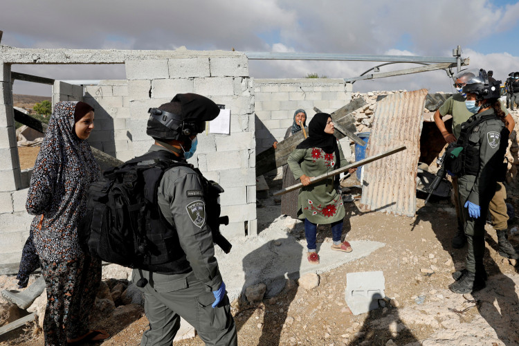 A Palestinian woman argues with Israeli border police officers