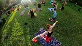 People hold glasses of wine as they perform wine yoga in Riga, Latvia August 8, 2020. 