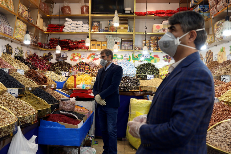 Men wear protective face masks and gloves, following the outbreak of coronavirus, as they are seen in a nuts shop in Tehran, Iran March 17, 2020.