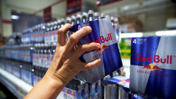 A woman buys Red Bull energy drink cans in a supermarket in Bangkok, Thailand, August 4, 2020.