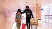 Maggie Zhang and her boyfriend Sunny Gu  walk towards the security checkpoint at Kingsford Smith International Airport