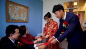 Pan Wenjun, 30, and Wei Jiawen, 29, receive red envelopes from Pan's parents