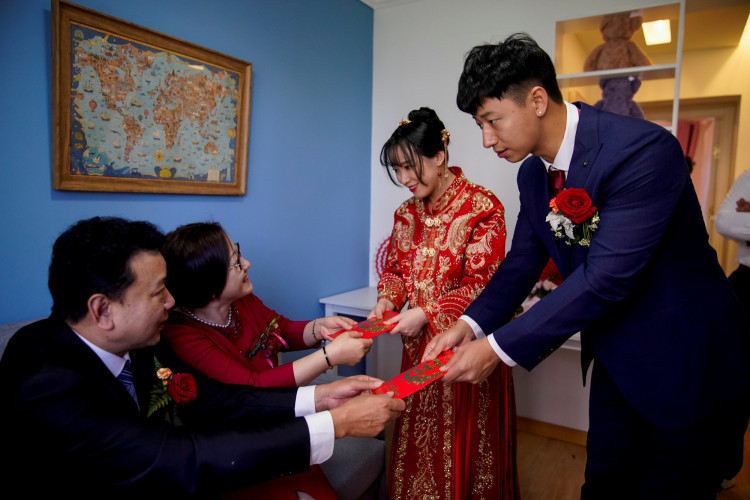 Pan Wenjun, 30, and Wei Jiawen, 29, receive red envelopes from Pan's parents