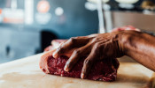 a butcher holding raw meat