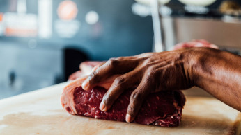 a butcher holding raw meat