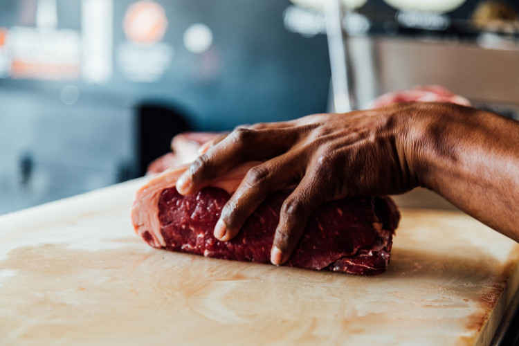 a butcher holding raw meat