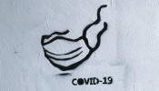 Street art - graffiti with facial mask on the wall during the current Coronavirus (COVID-19) pandemic in Warsaw, Poland
