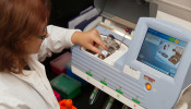 A female lab technician loading a semiconductor DNA sequencing chip